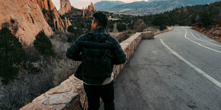 person at the side of the road looking at the mountains far away